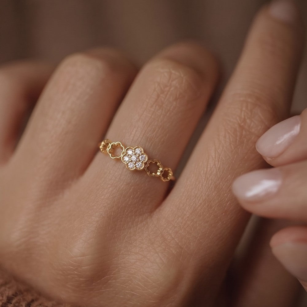 Gold ring with floral design on a person's finger