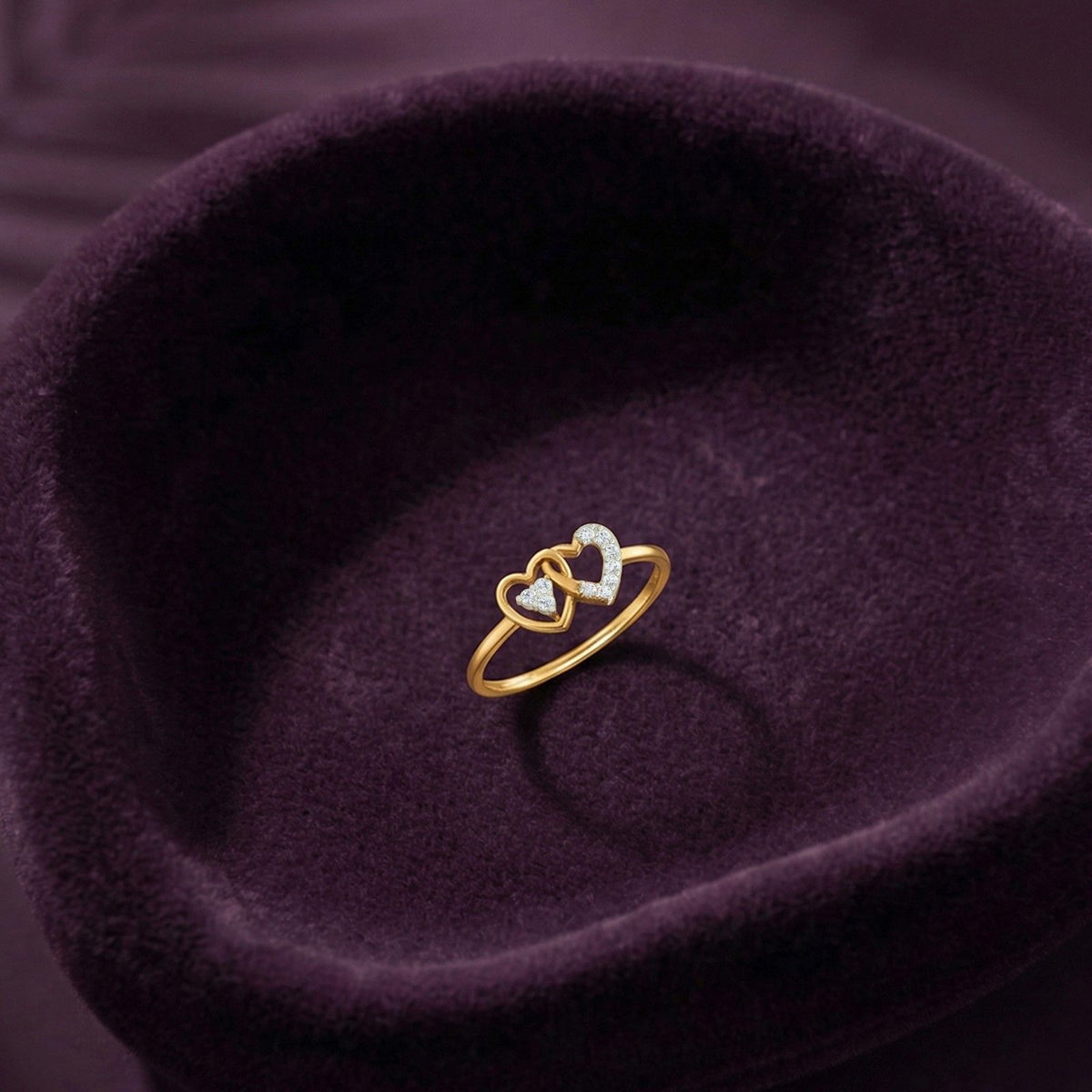 Gold and diamond with heart-shaped and cluster setting on a fabric surface.