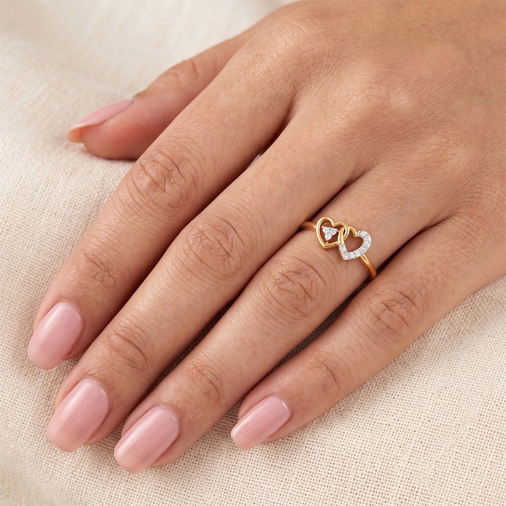 Gold and diamond with heart-shaped and cluster setting on a person's finger.
