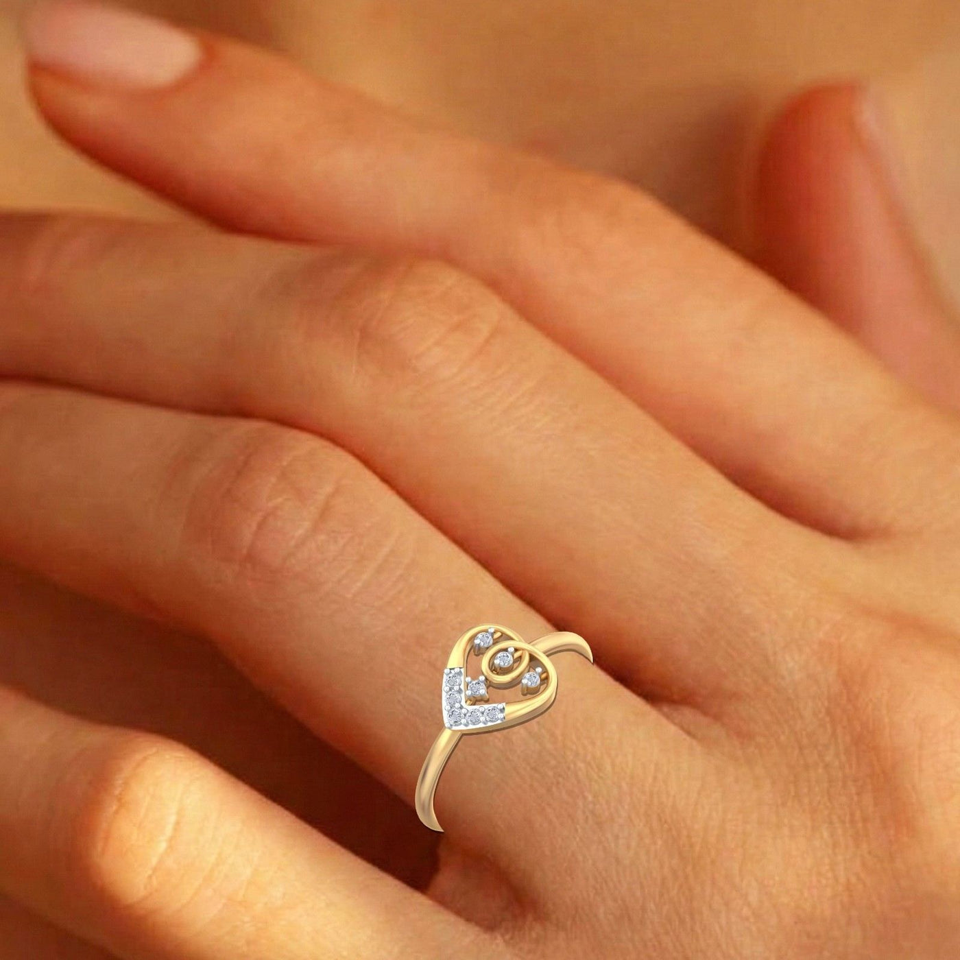 Gold and diamond heart-shaped ring on a person's finger
