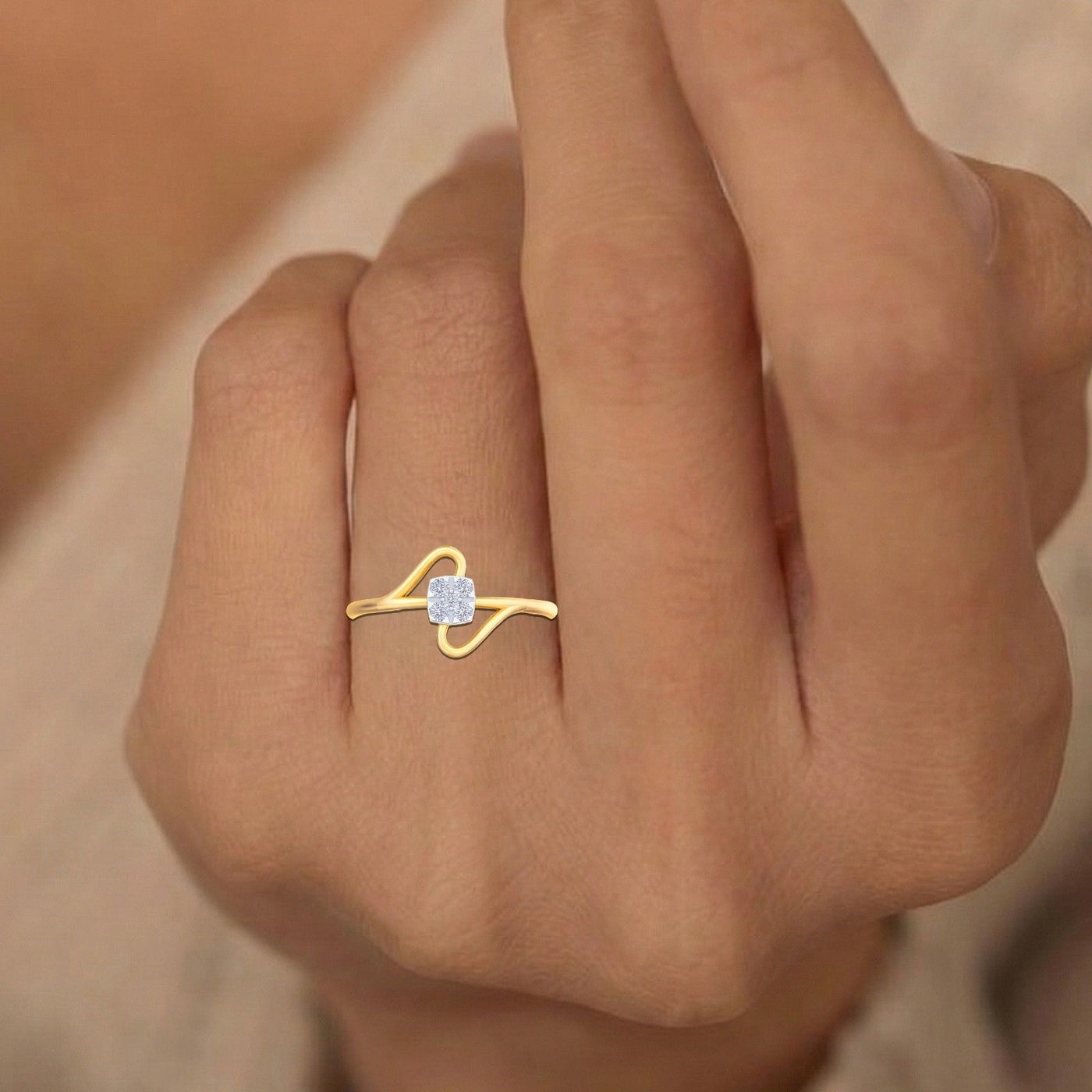 Gold ring with a diamond on a person's finger against a neutral background