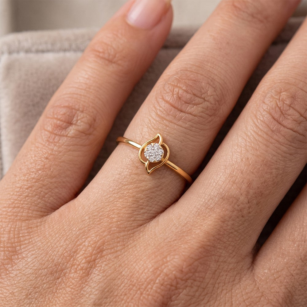 Gold and diamond with round-shaped cluster setting on a person's finger.