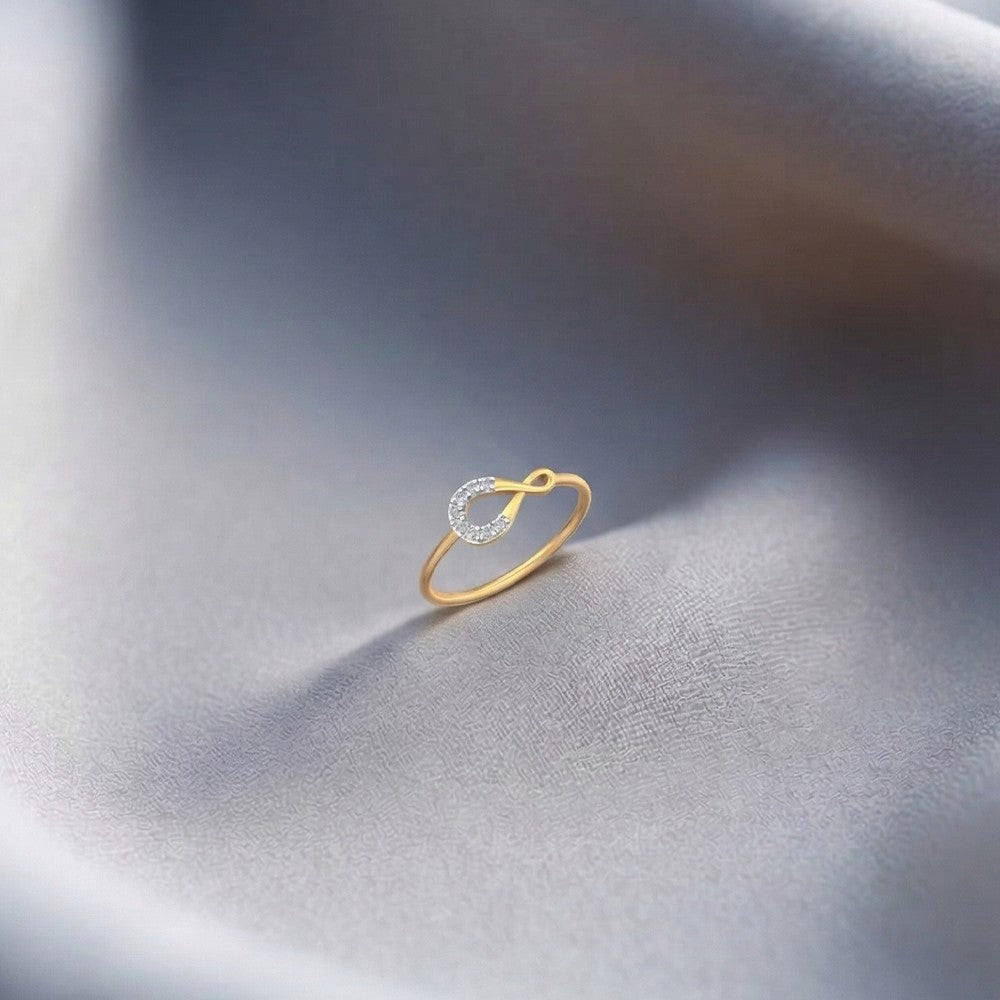 Gold and diamond women's ring on a grey surface.