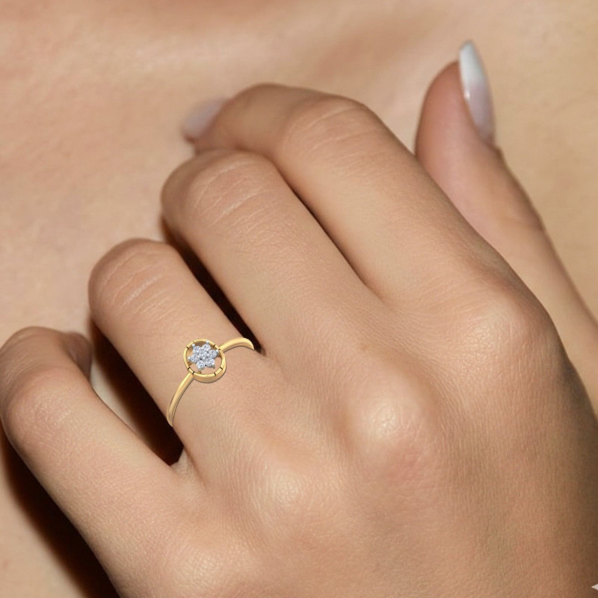 Gold and diamond with floral-design cluster setting on a person's finger.