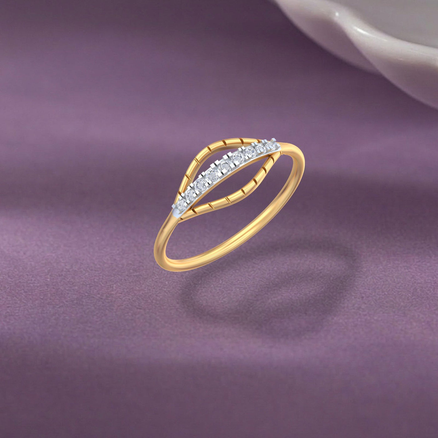 Gold and diamond with half-eternity on a purple surface.