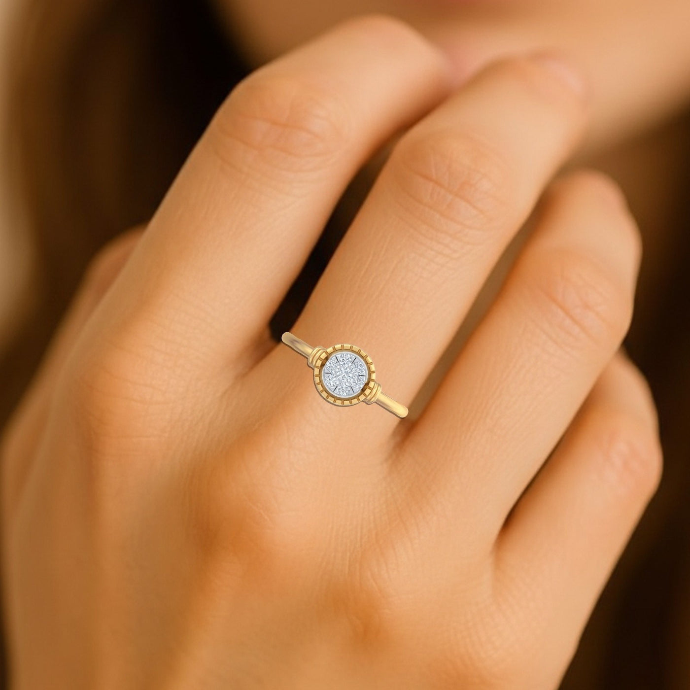 Gold and diamond ring with a halo design on a hand against a blurred background