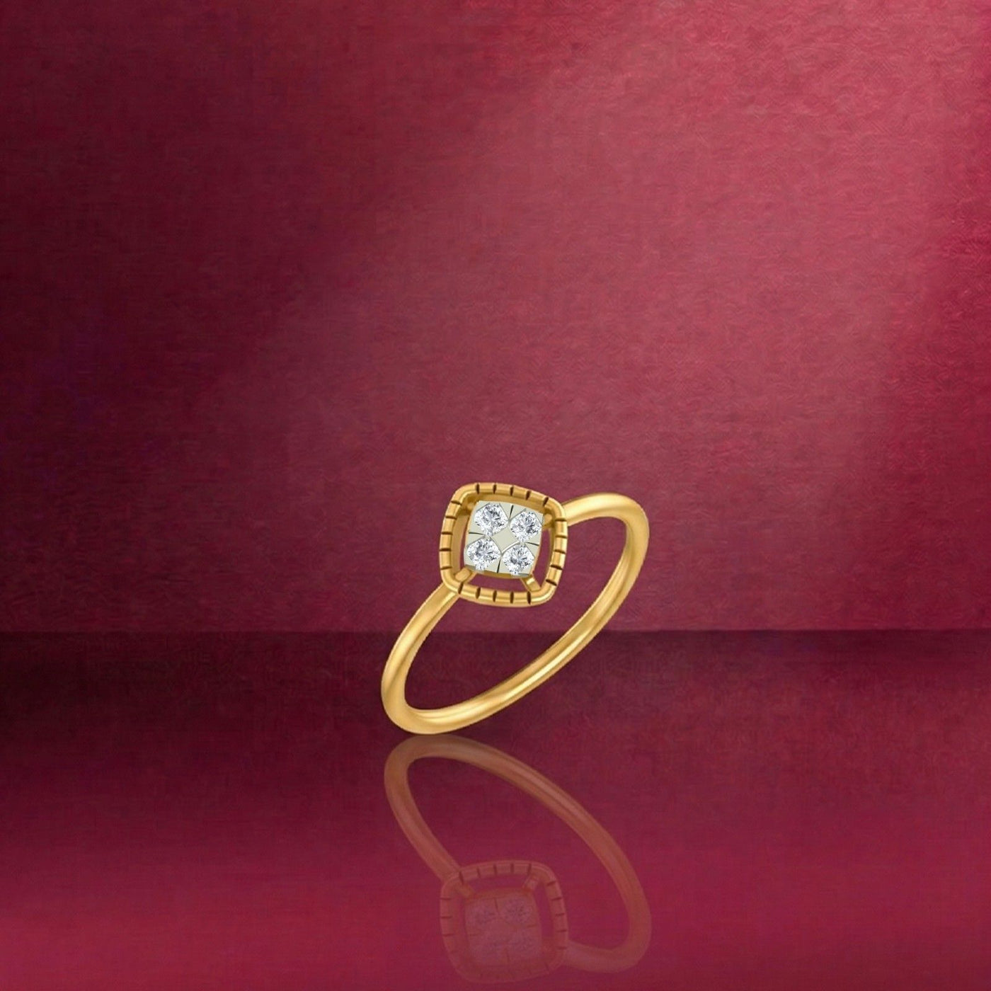 Gold and diamond with square-shaped cluster setting on a red reflective surface.