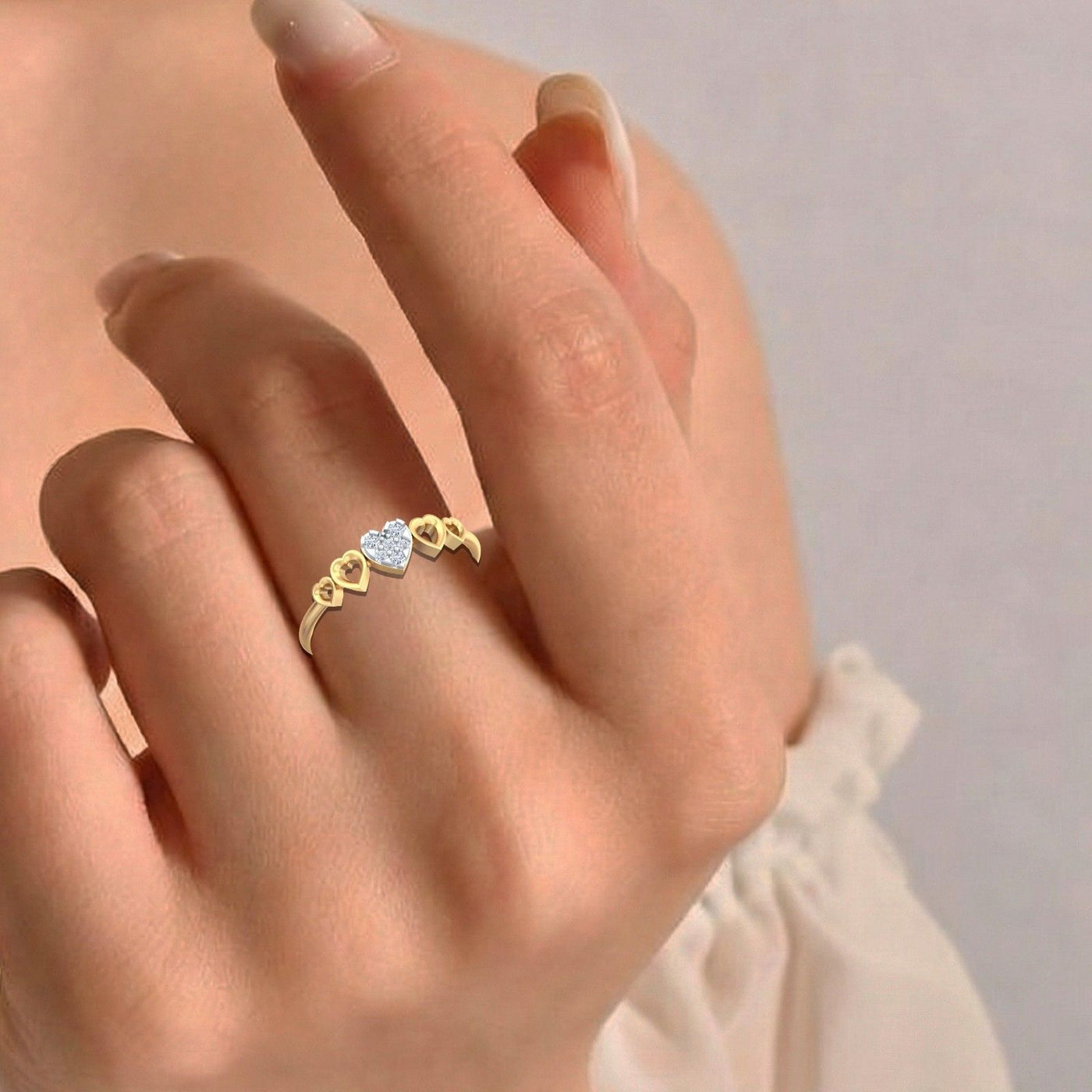 Gold ring with a heart-shaped cluster on a hand against a neutral background