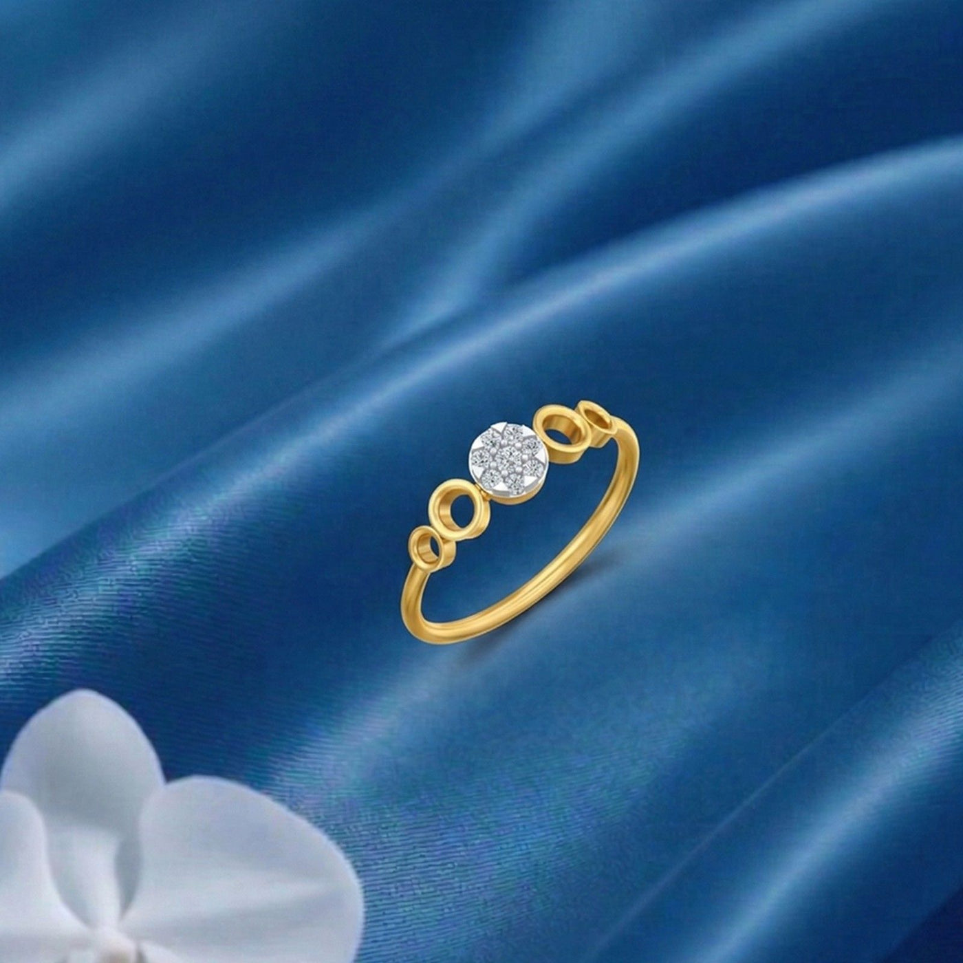 Gold and diamond with round-shaped cluster setting on a blue surface.