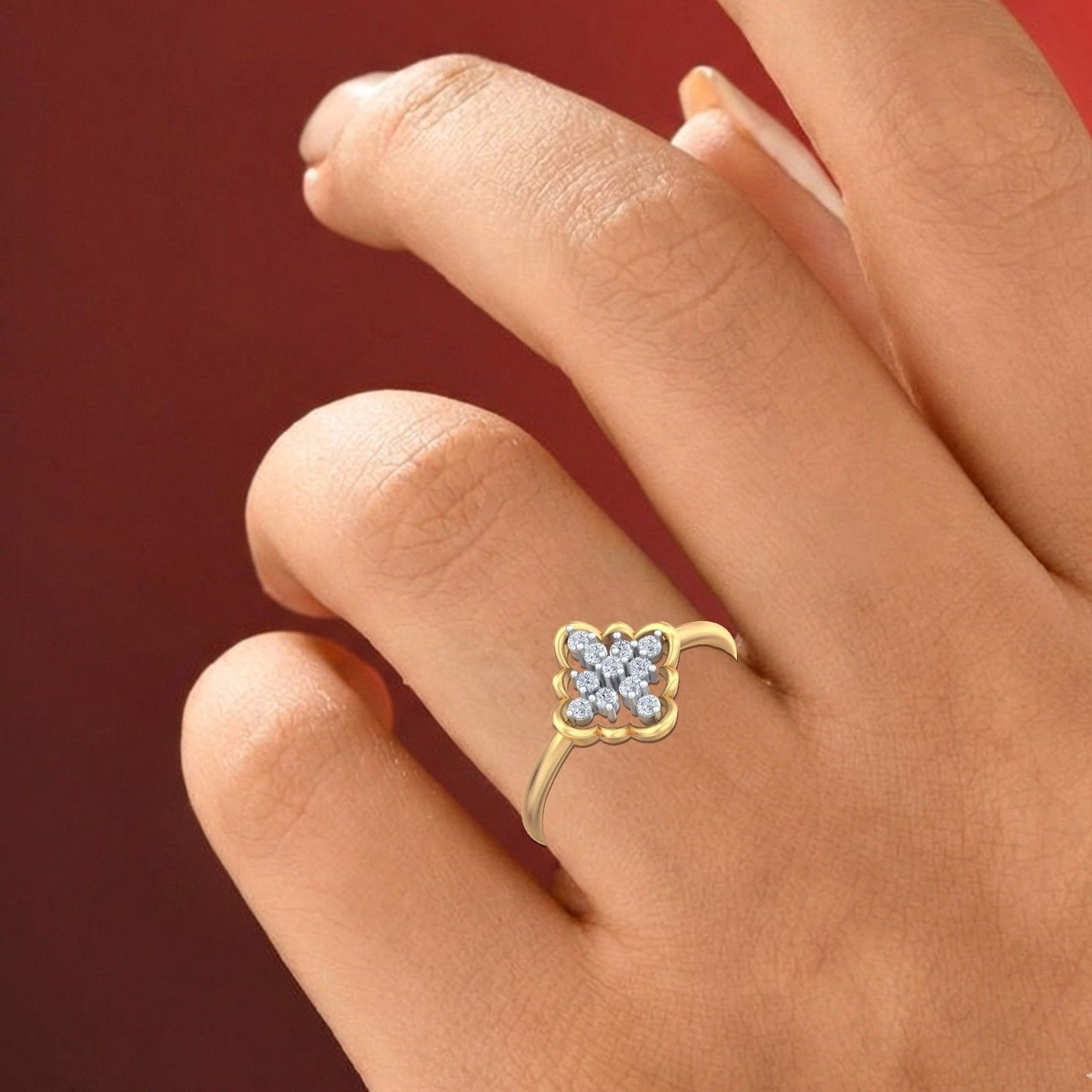 Gold ring with a diamond on a hand against a red background