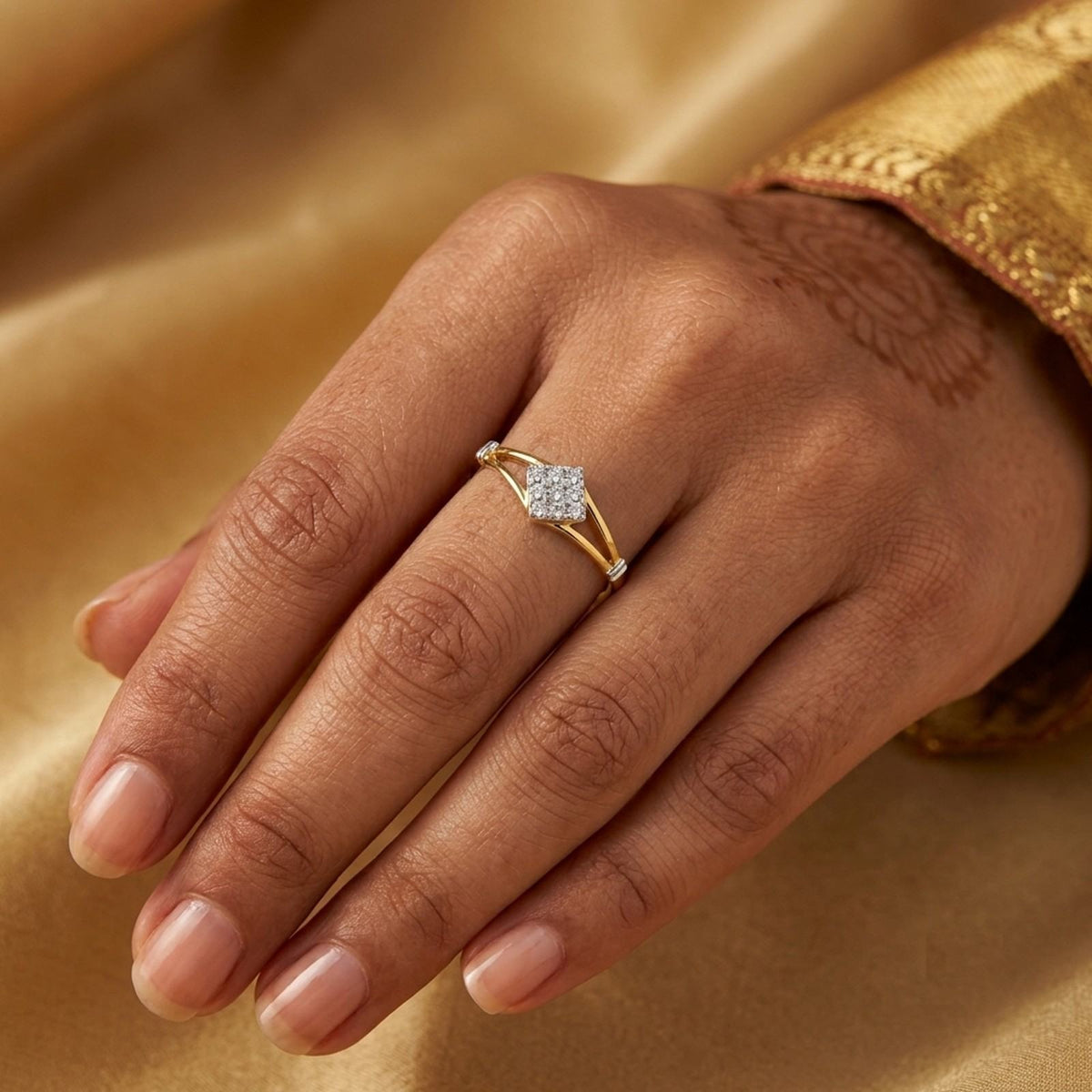 Gold ring with a diamond on a person's finger against a mustard background