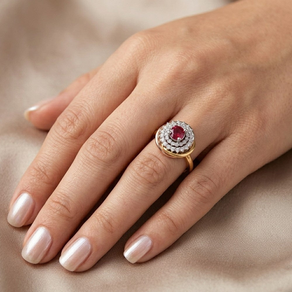 Hand wearing a gold ring with a red gemstone on a beige fabric background