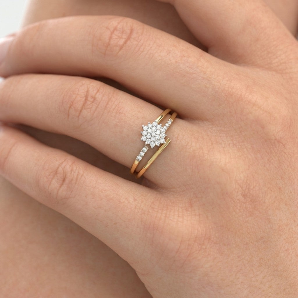 Gold ring with a floral center and diamond accents on a person's finger.