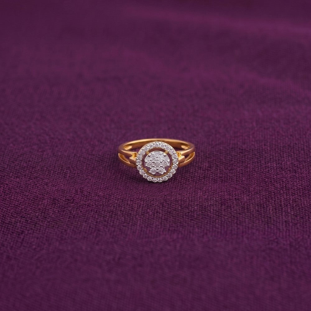 Gold and diamond with cluster halo design ring on a purple surface.