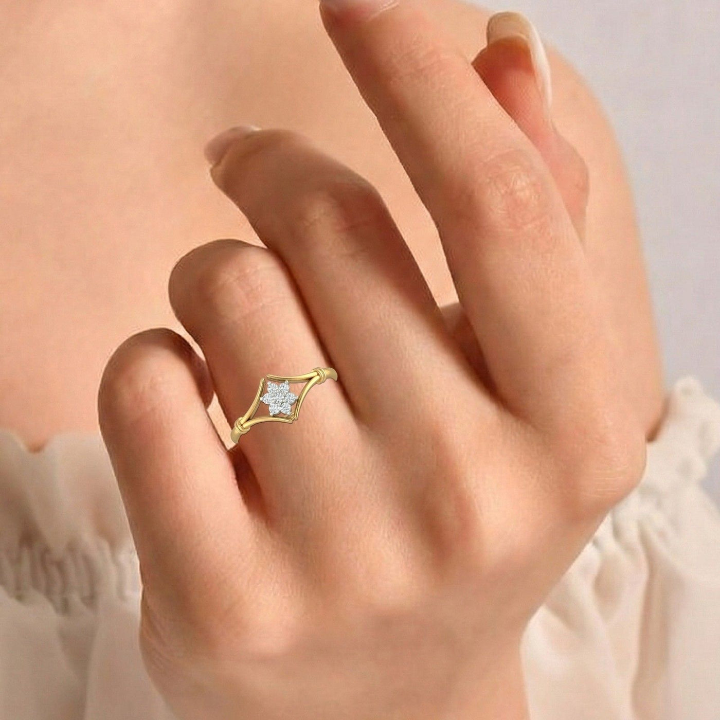 Gold ring with a diamond floral design on a hand against a blurred background