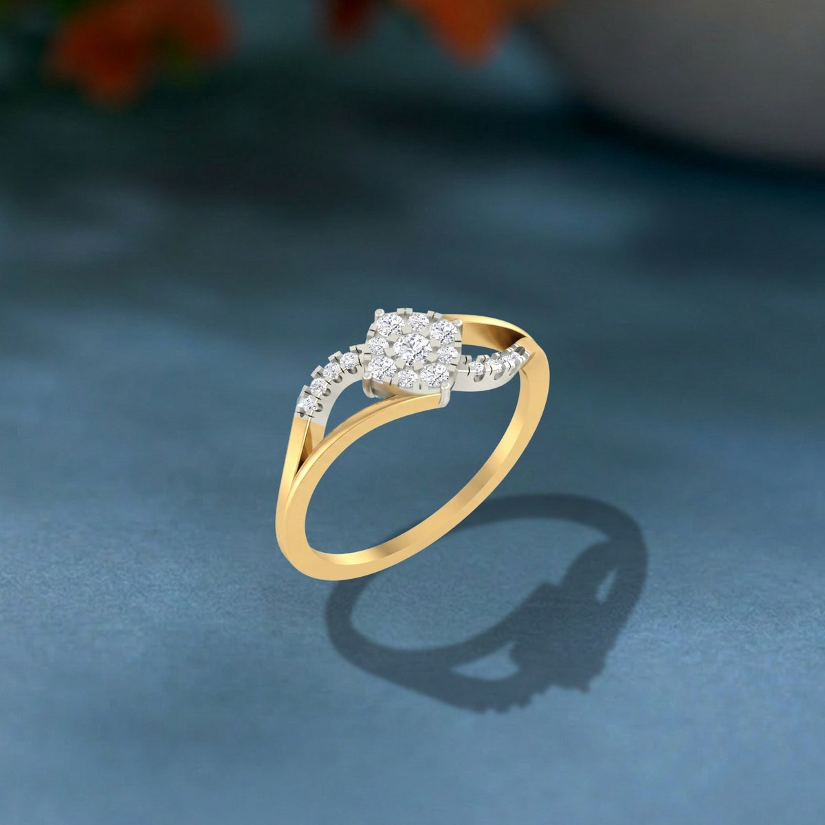 Gold and diamond with cluster setting on a teal surface.