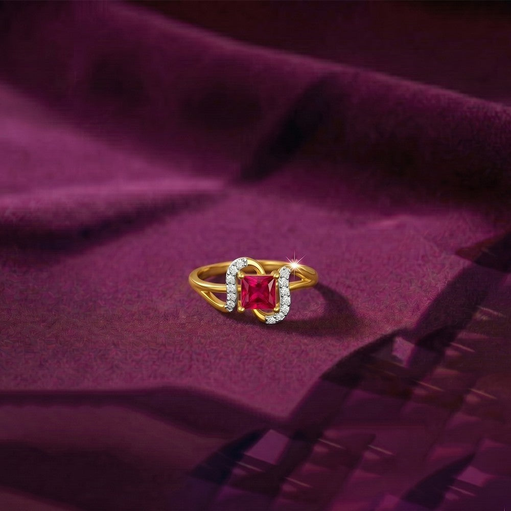 Gold and diamond with ruby gemstone on a fabric surface.