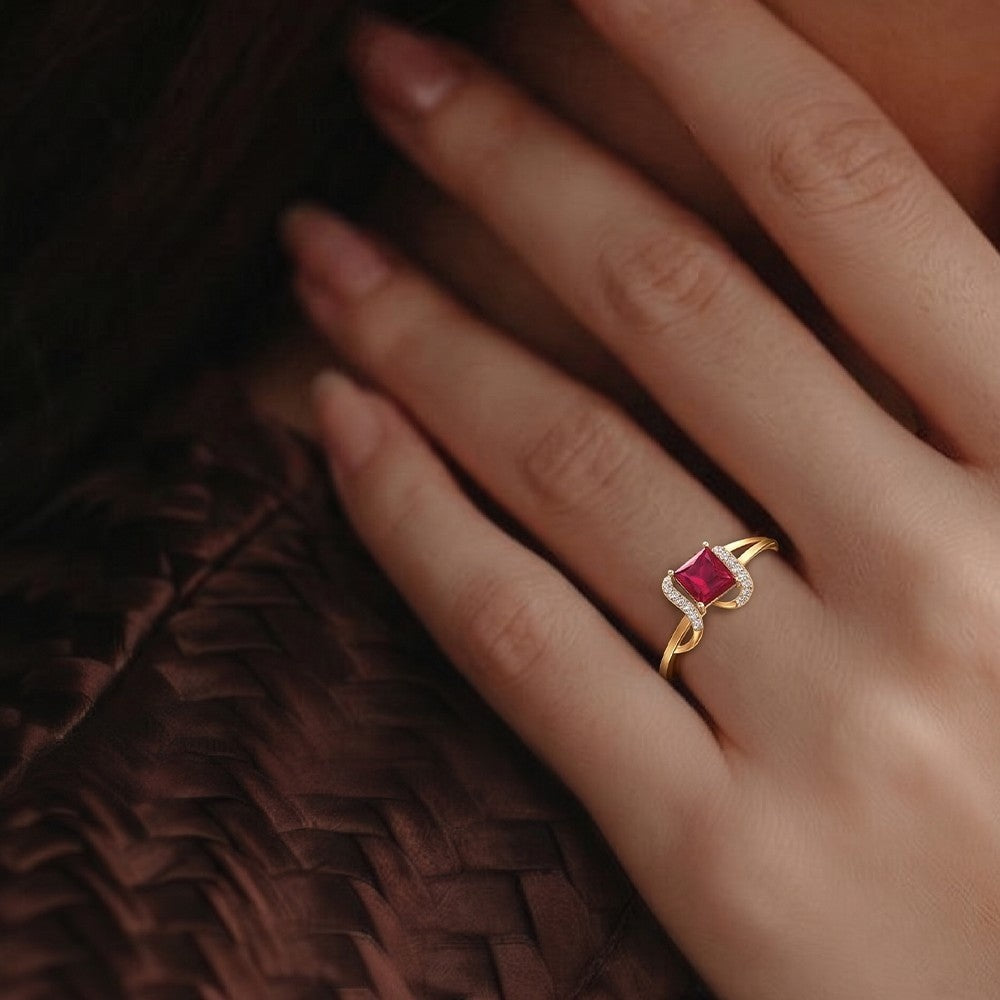 Close-up shot of a gold and diamond with ruby women's ring.