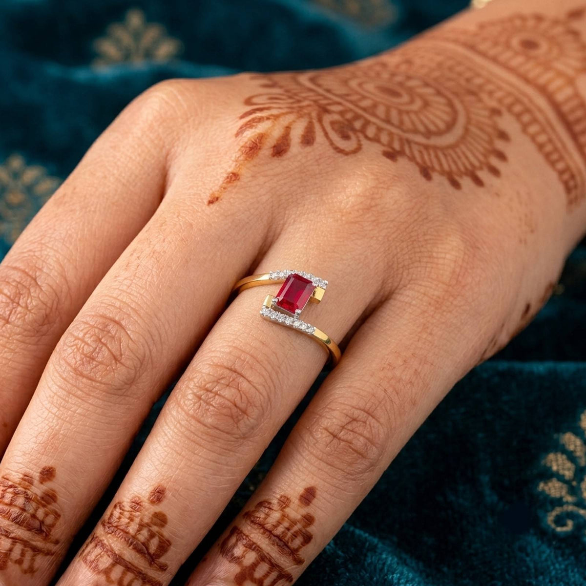 Gold ring featuring a rectangular ruby center, shown on a person's finger.