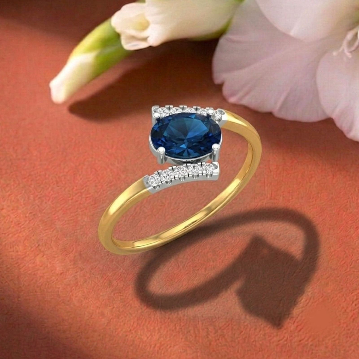 Gold ring with a sapphire gemstone on a orange fabric background