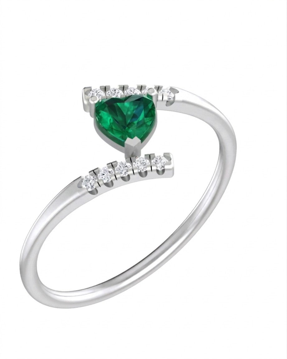 White gold and diamond ring with a heart-shaped emerald on a white background