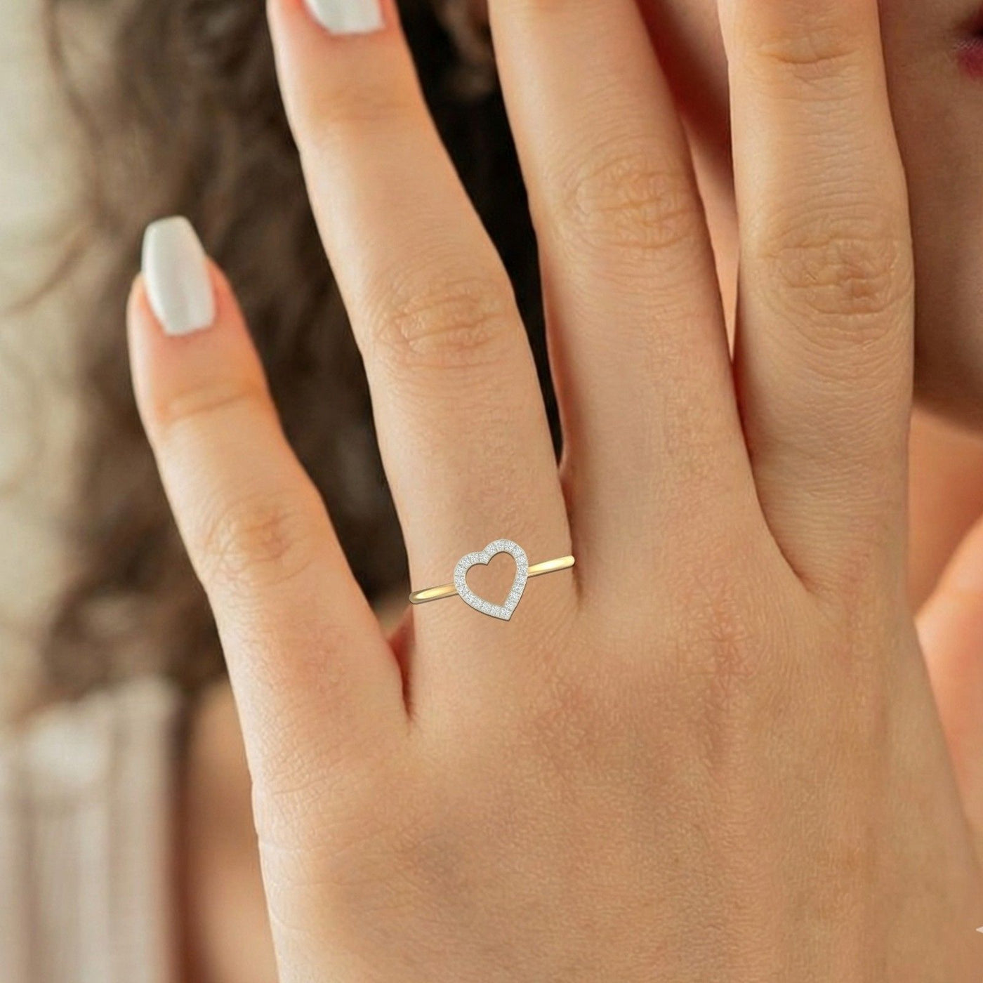 Close-up shot of a gold and diamond with heart-shaped ring.
