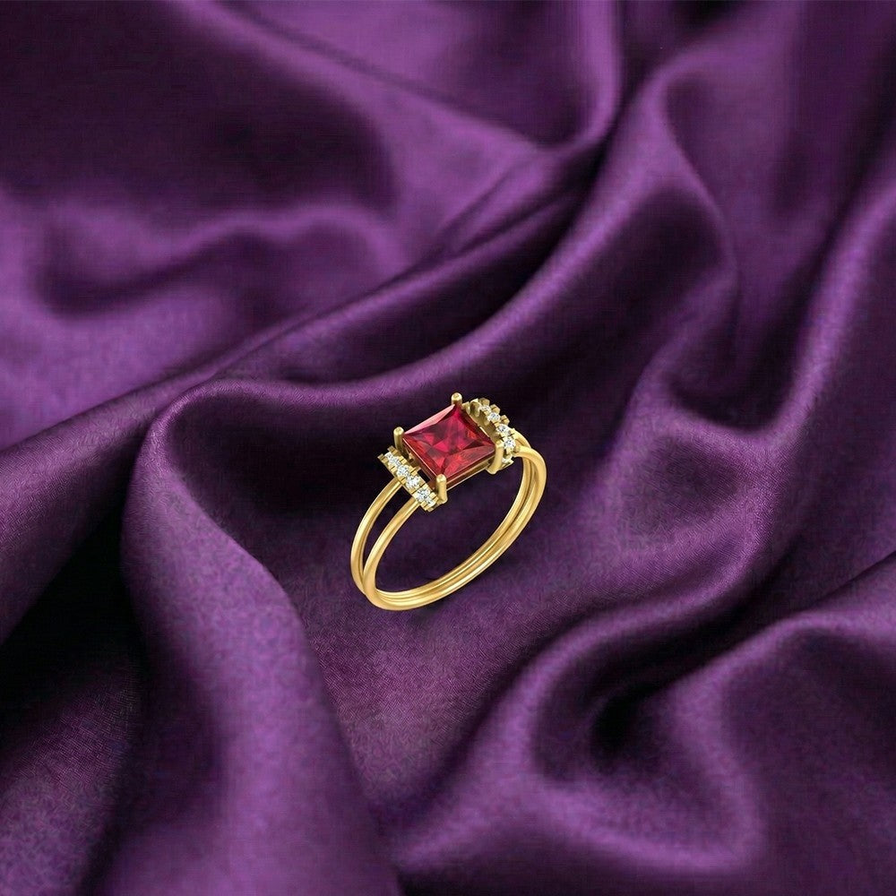 Gold and diamond with ruby gemstone on a fabric surface.
