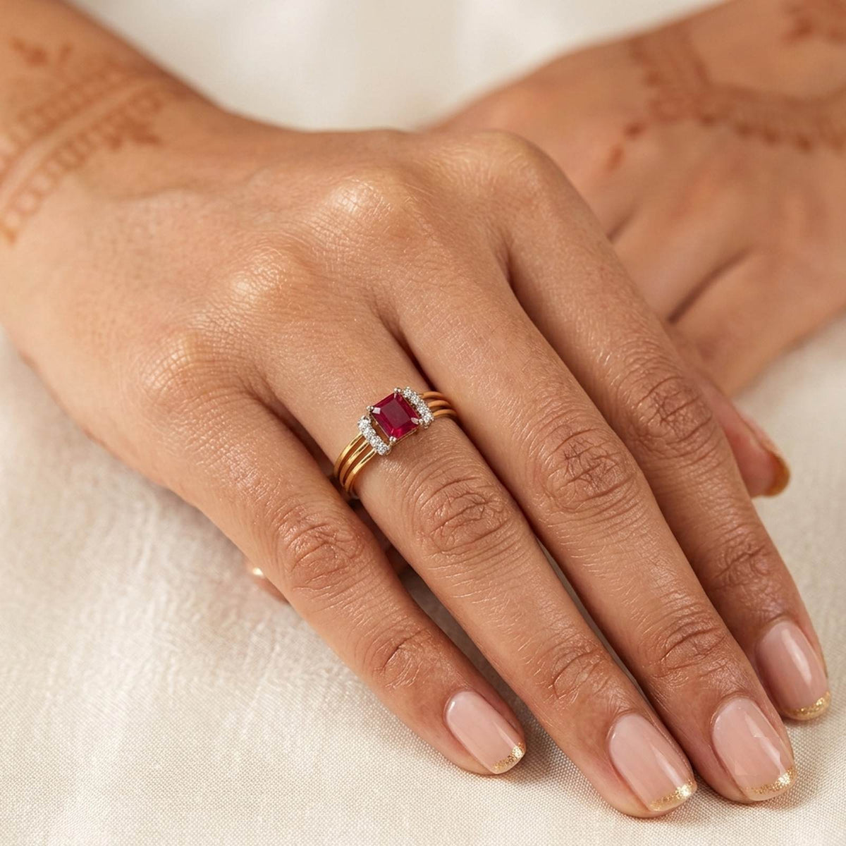 Gold and diamond with ruby gemstone on a person's finger.