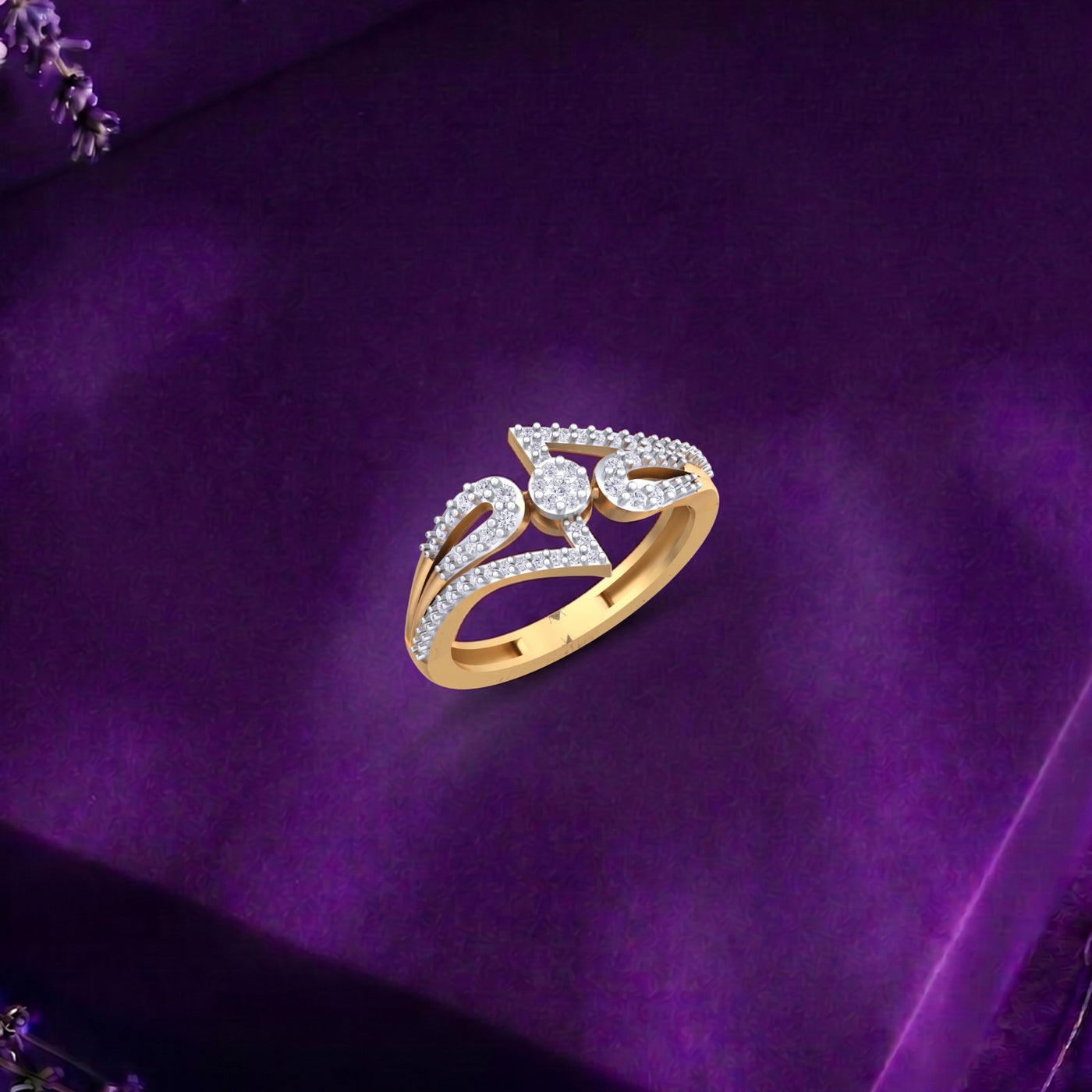 A gold ring with pavé-set clear stones arranged in a stylized abstract design, displayed on a textured purple velvet surface.