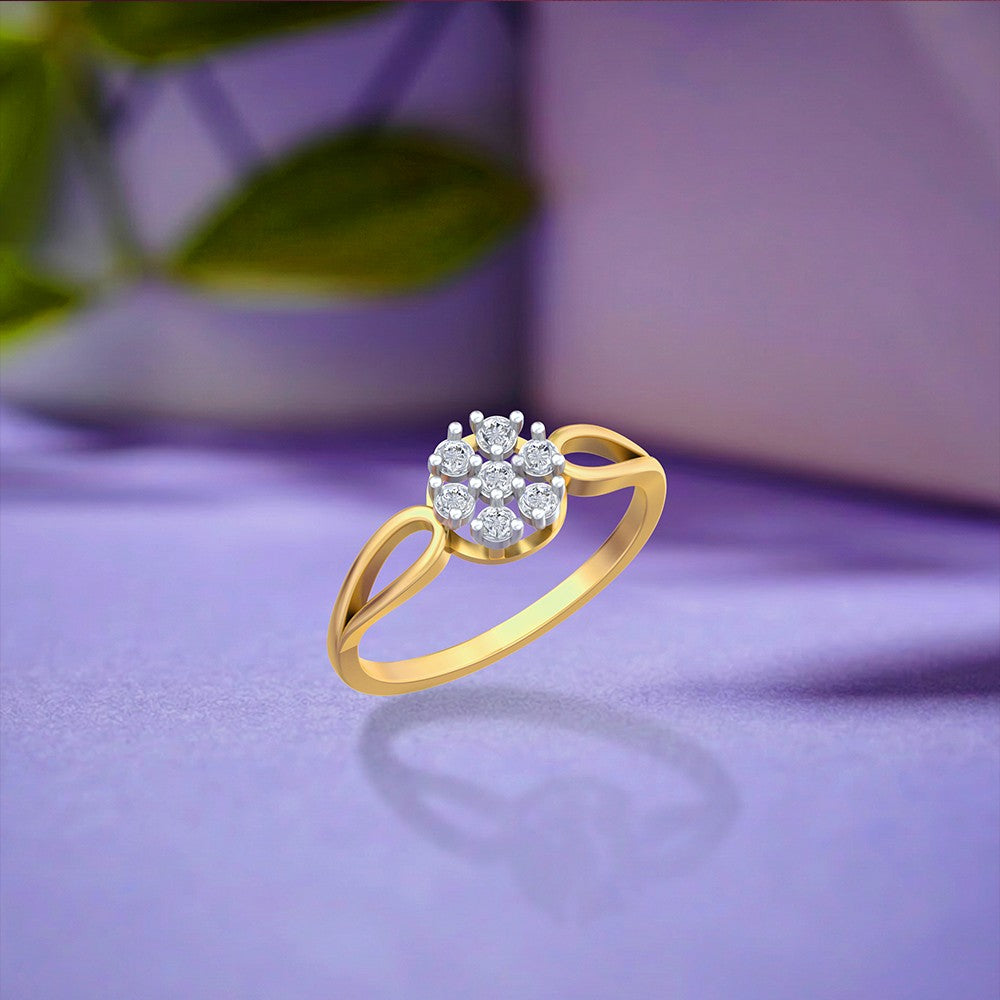 A gold ring with a round cluster, resting on a soft purple surface with a blurred background.