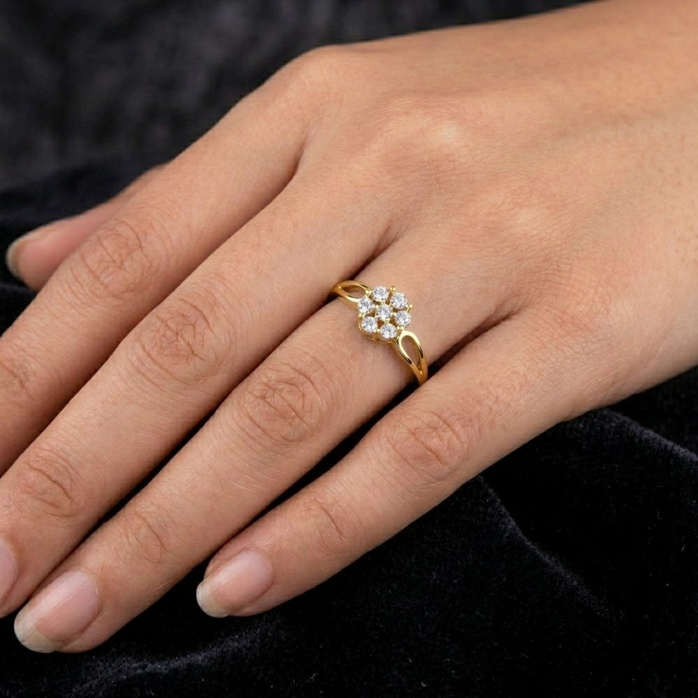 Gold ring with diamonds on a person's finger against a dark background