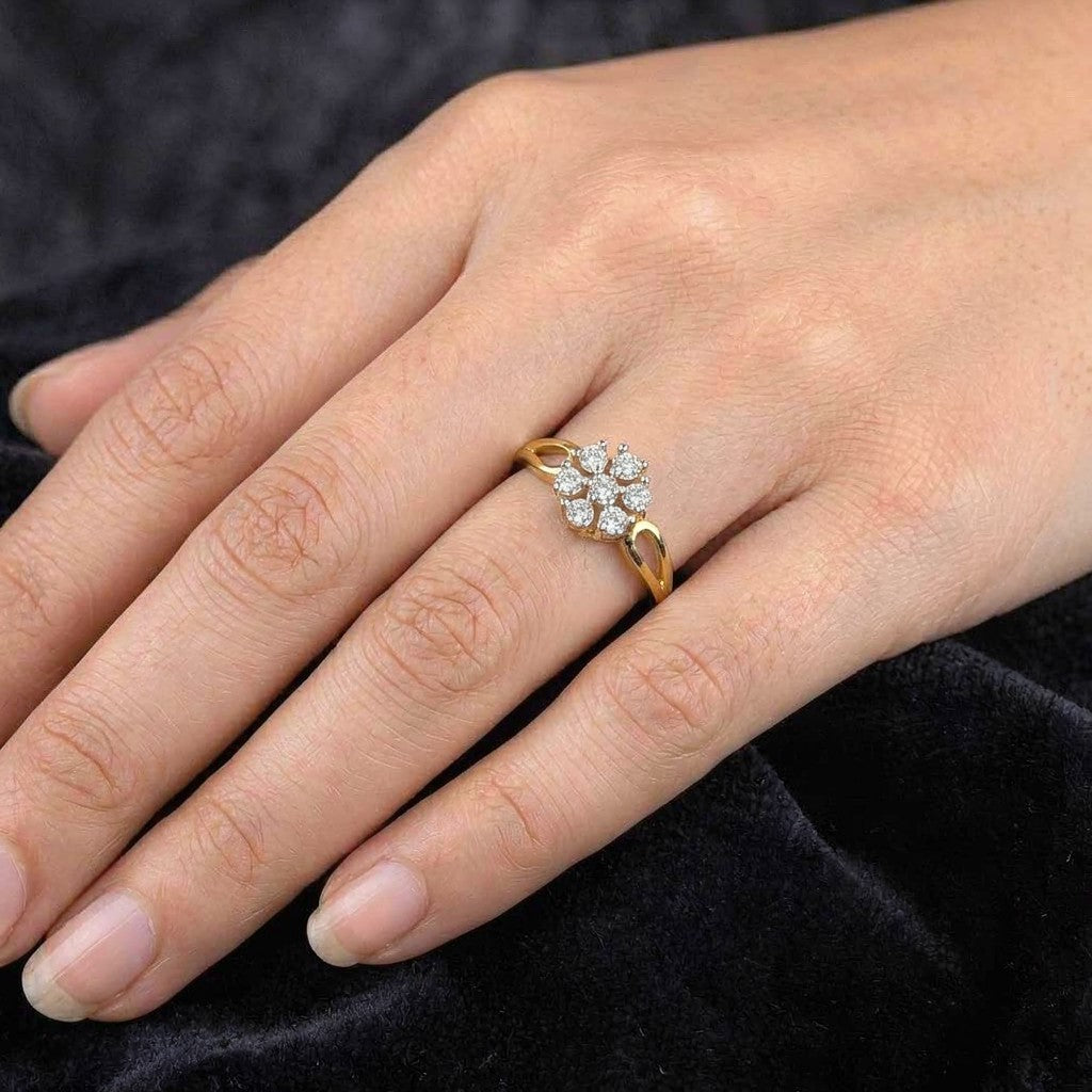 Gold ring with diamonds on a person's finger against a dark background