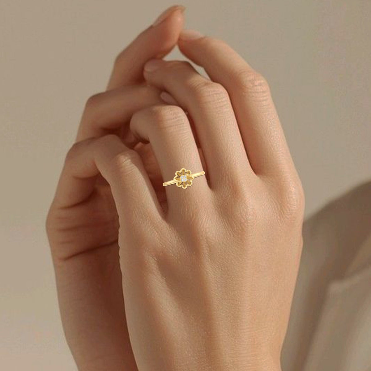 Gold and diamond with floral-design on a person's finger.