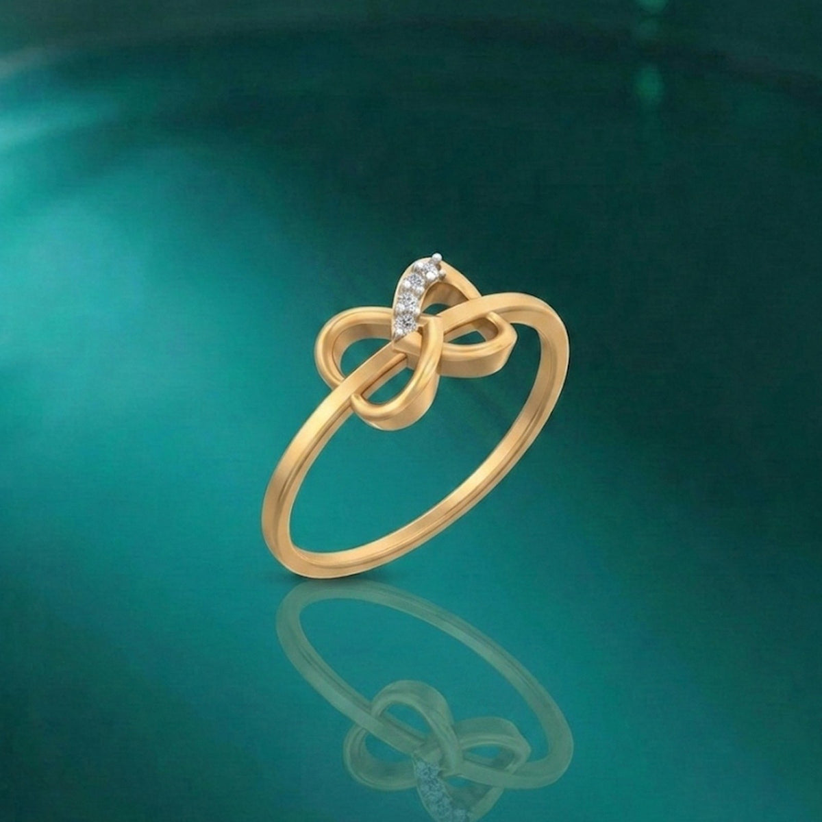 Gold and diamond women's ring on a reflective surface.