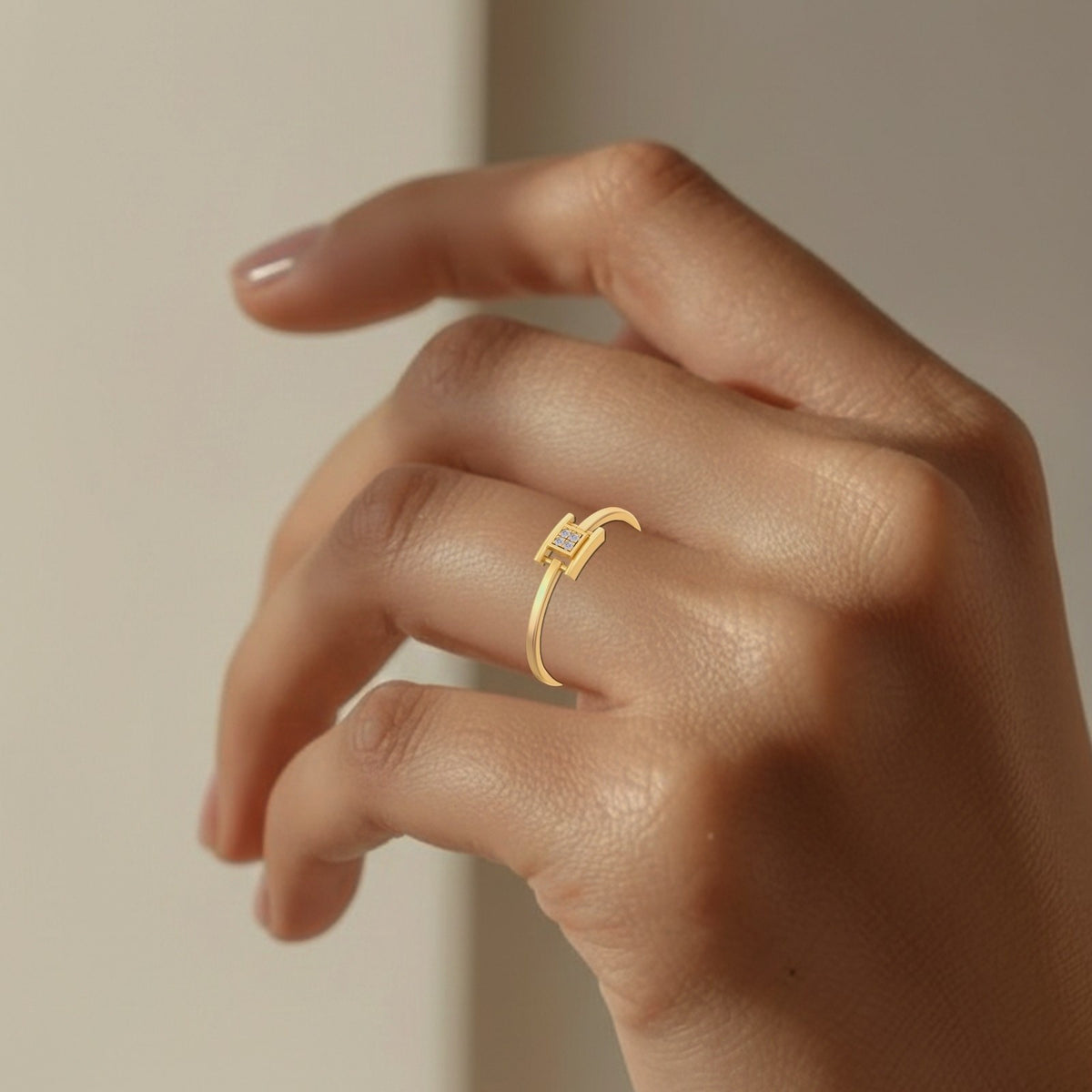 Gold ring on a person's finger against a neutral background