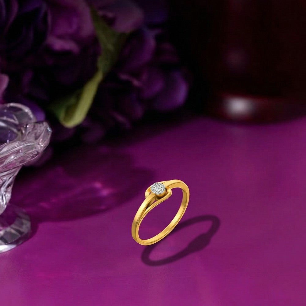 Gold ring with a diamond on a purple surface with flowers in the background