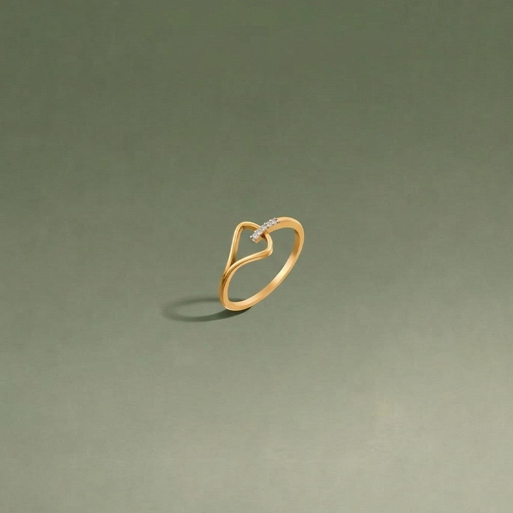 Gold and diamond women's ring on a green surface.