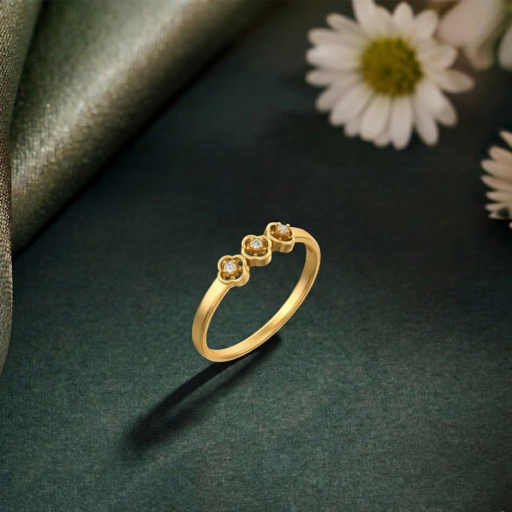 Gold and diamond women's ring on a green surface.