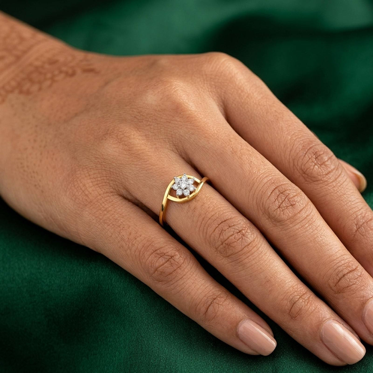Gold and diamond with floral cluster setting on a person's finger.