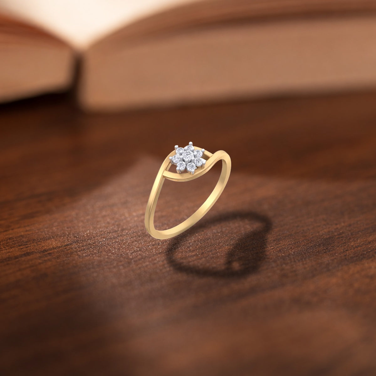 Gold and diamond with floral cluster setting on a wooden surface.