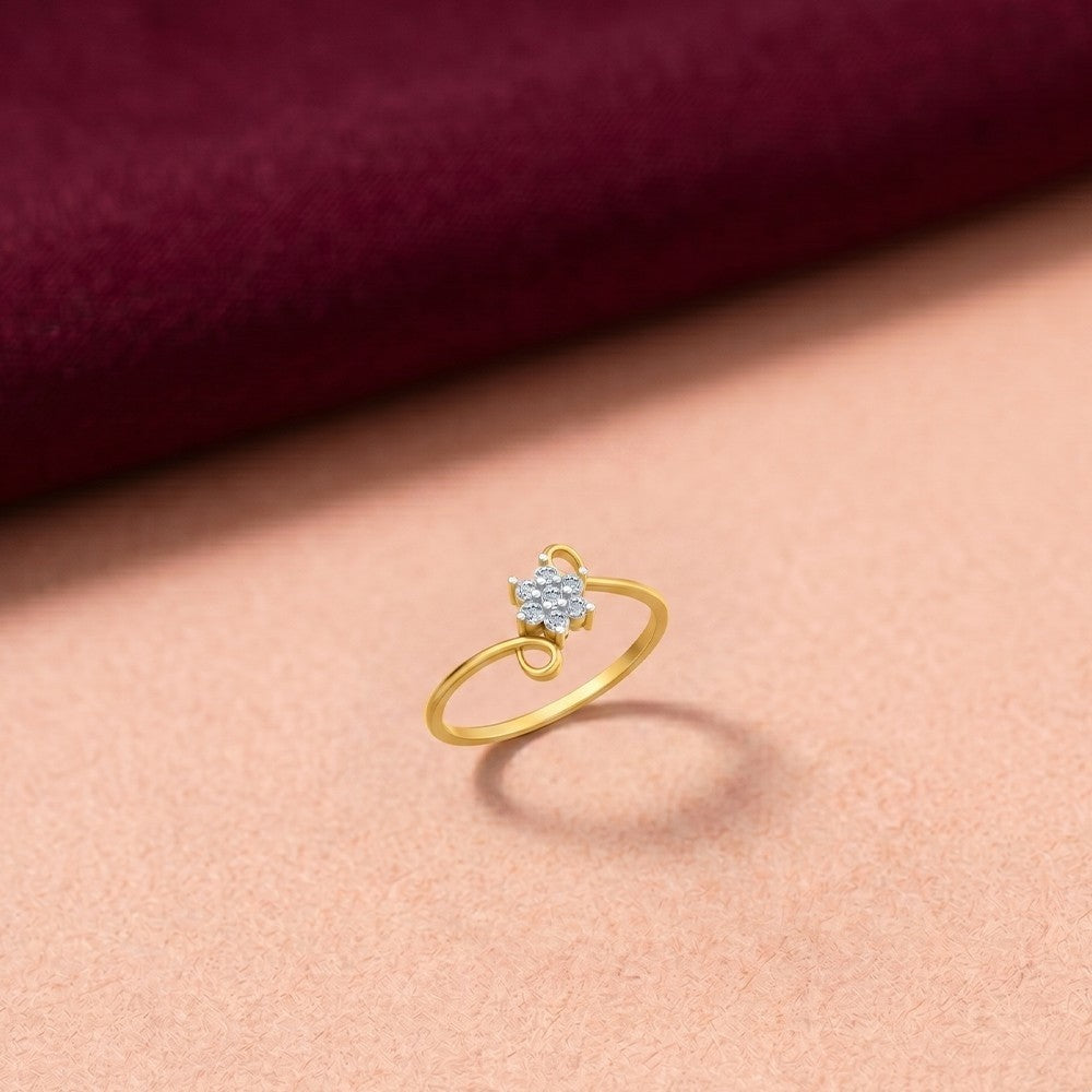 Gold ring with a diamond on a pink fabric background.