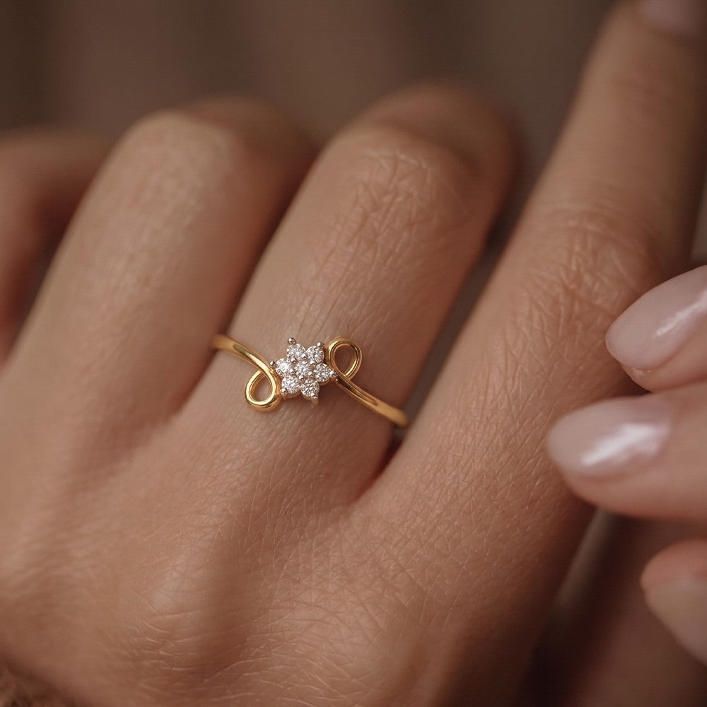 Gold ring with a diamond on a person's finger against a neutral background