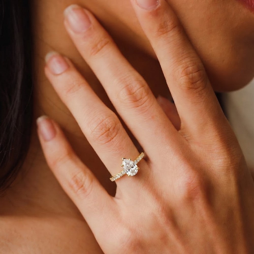 Close-up of a hand wearing a diamond ring with a soft focus background