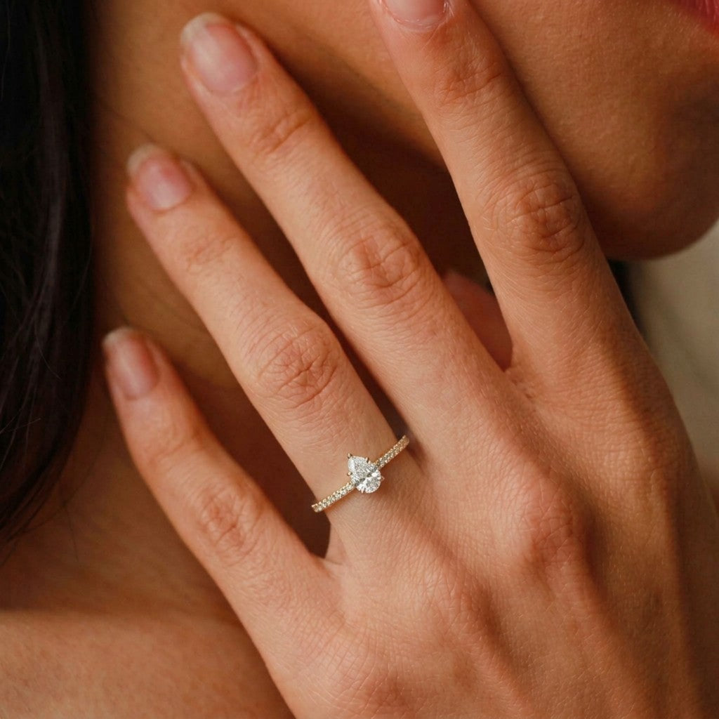 Close-up of a hand wearing a diamond ring with a soft focus background