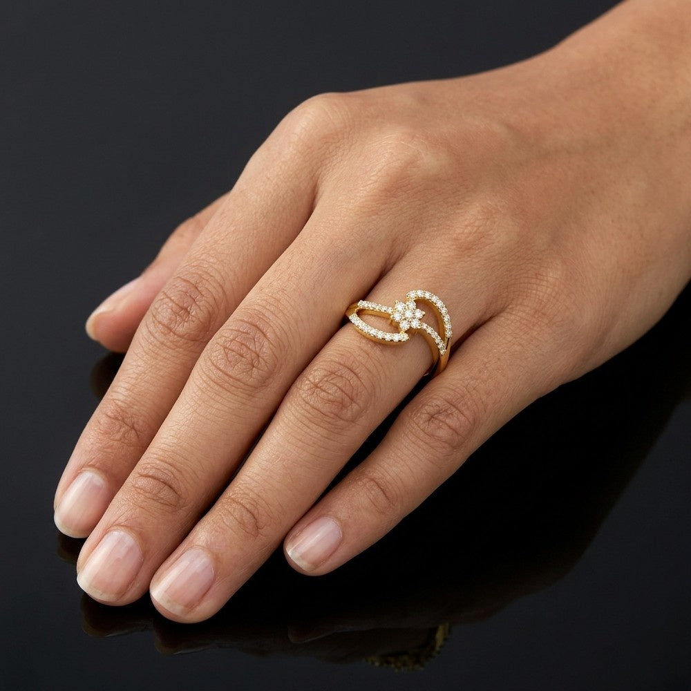 Hand wearing a gold ring with a diamond on a dark background