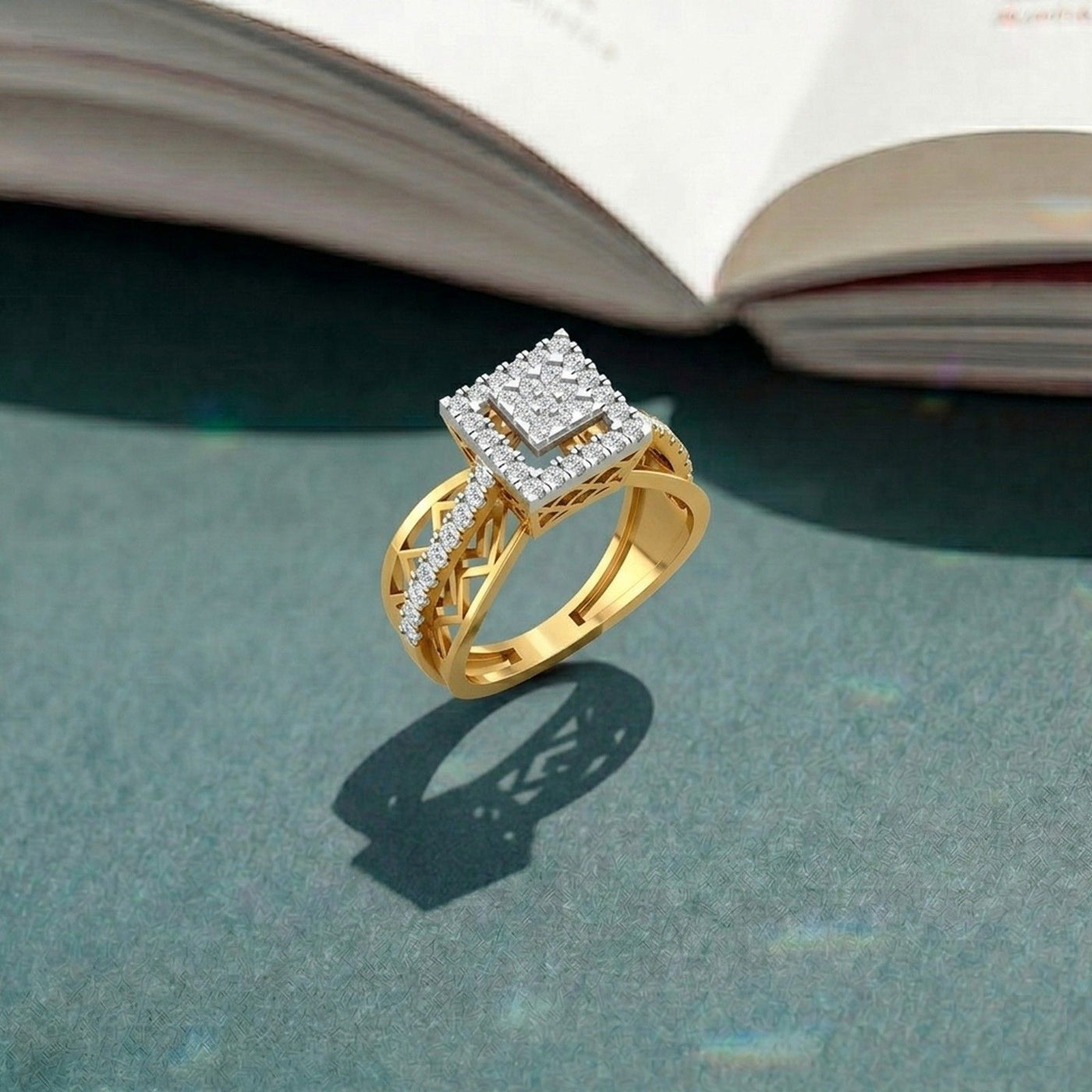 Gold ring with diamond accents on a textured surface with an open book in the background