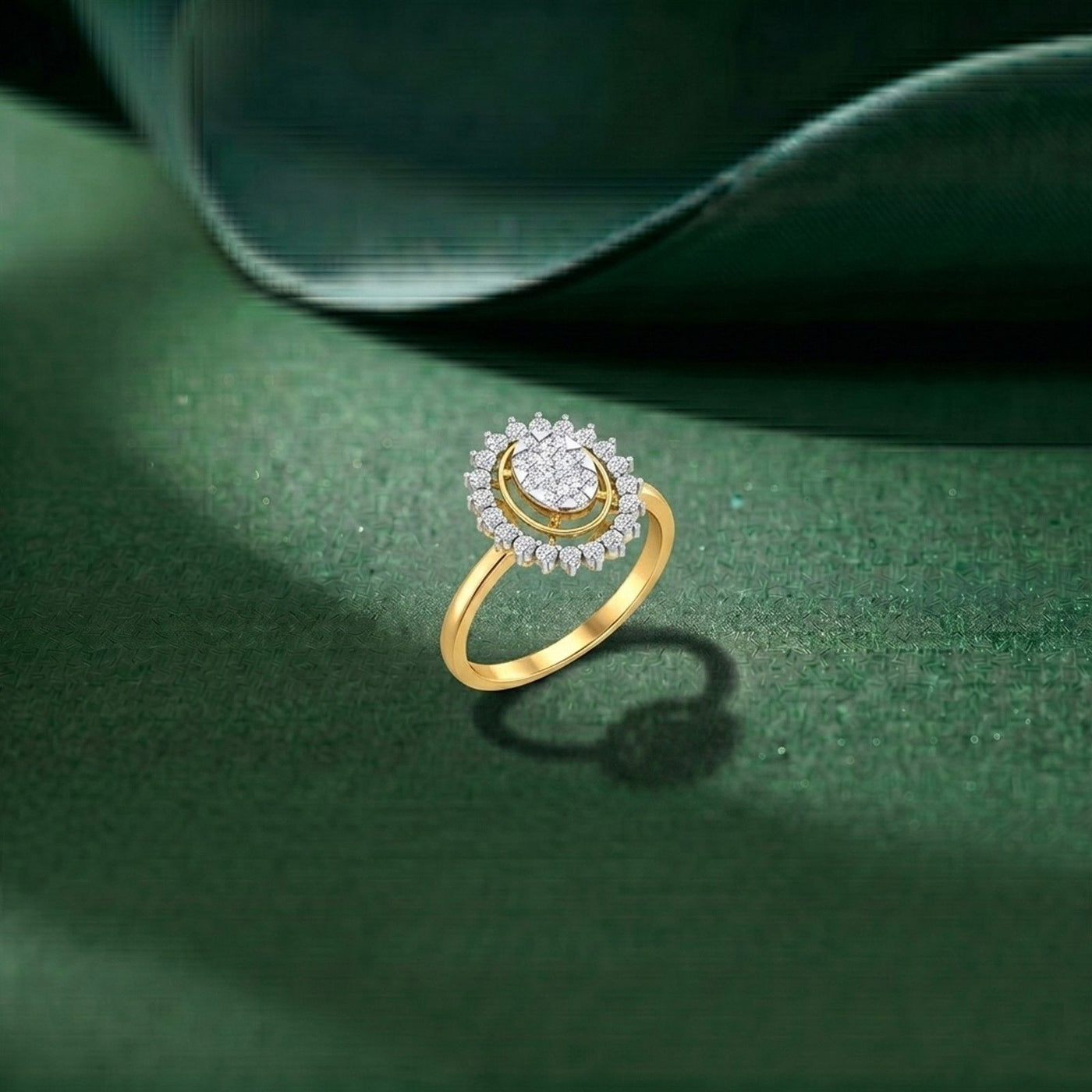 A gold and diamond ring with a halo, displayed on a dark green textured surface.