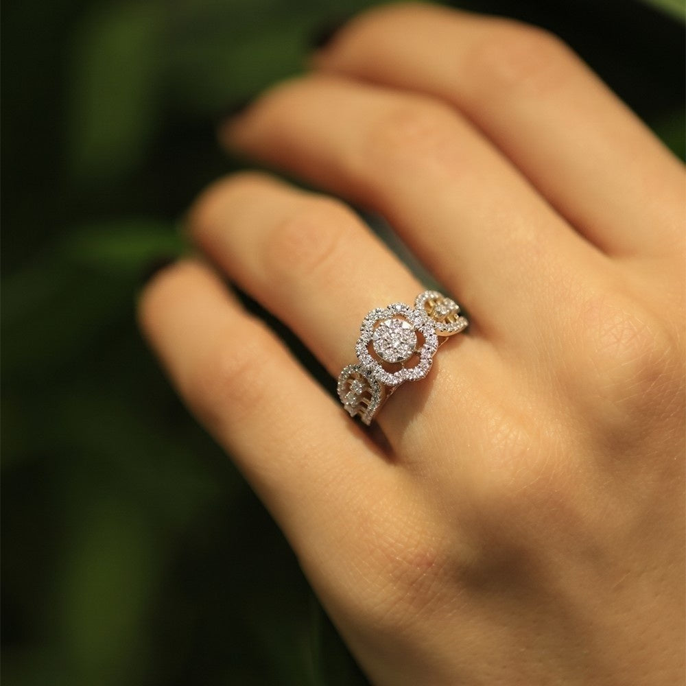 Close-up of a hand wearing a decorative ring with a blurred green background.