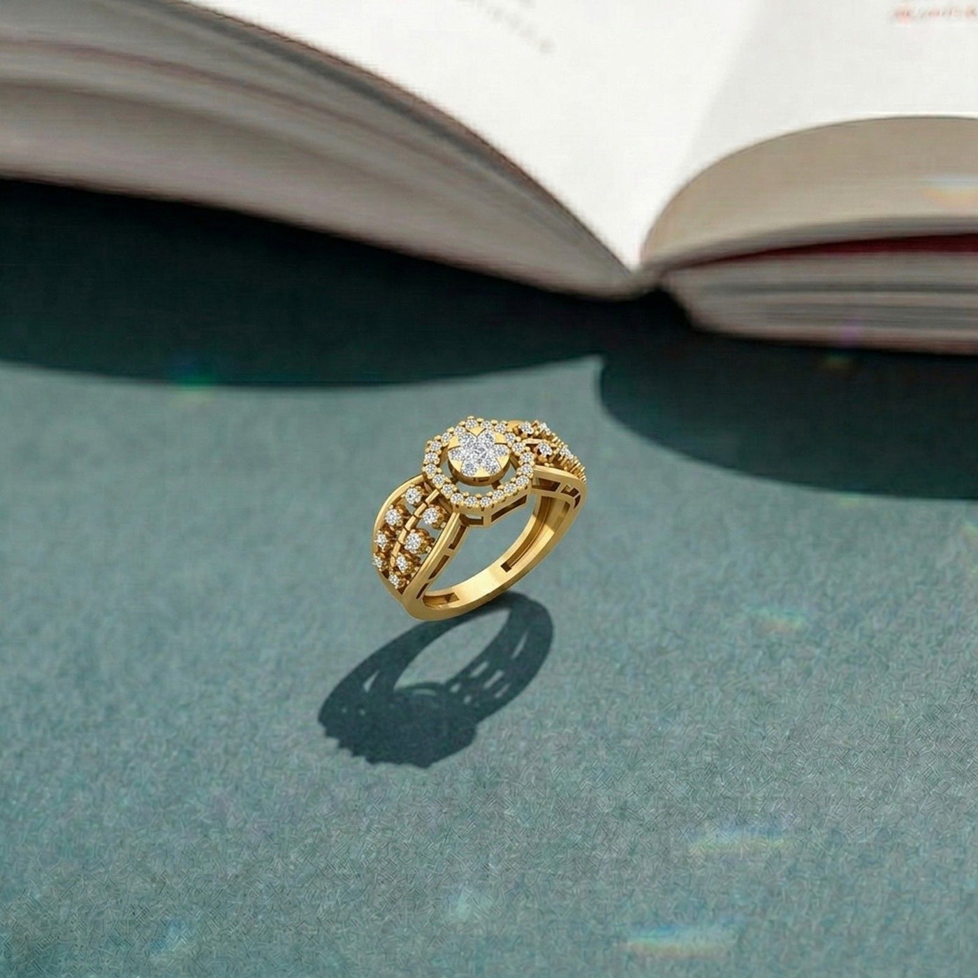 Gold ring with diamonds on a textured surface with an open book in the background.