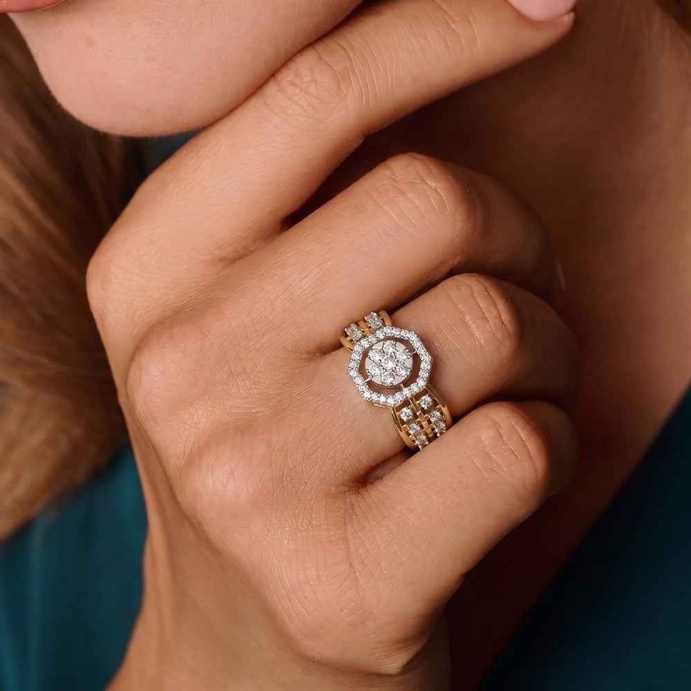 Close-up of a hand wearing a rose gold ring with a diamond, against a blurred background.